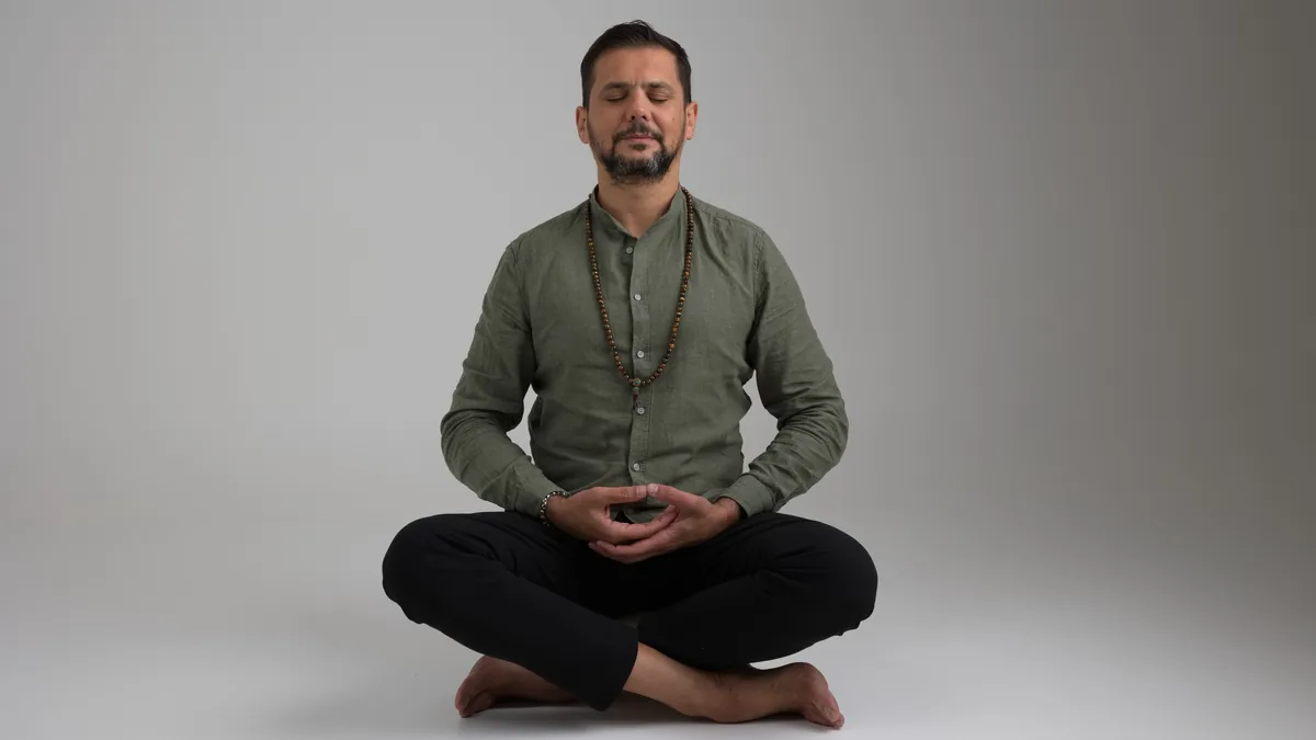 Antonio Antefermo, lo Psicologo Zen, seduto in meditazione a gambe incrociate su fondo neutro